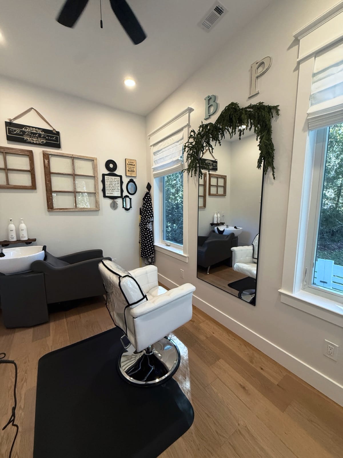 The one-chair studio with vintage window frames and The Back Porch sign