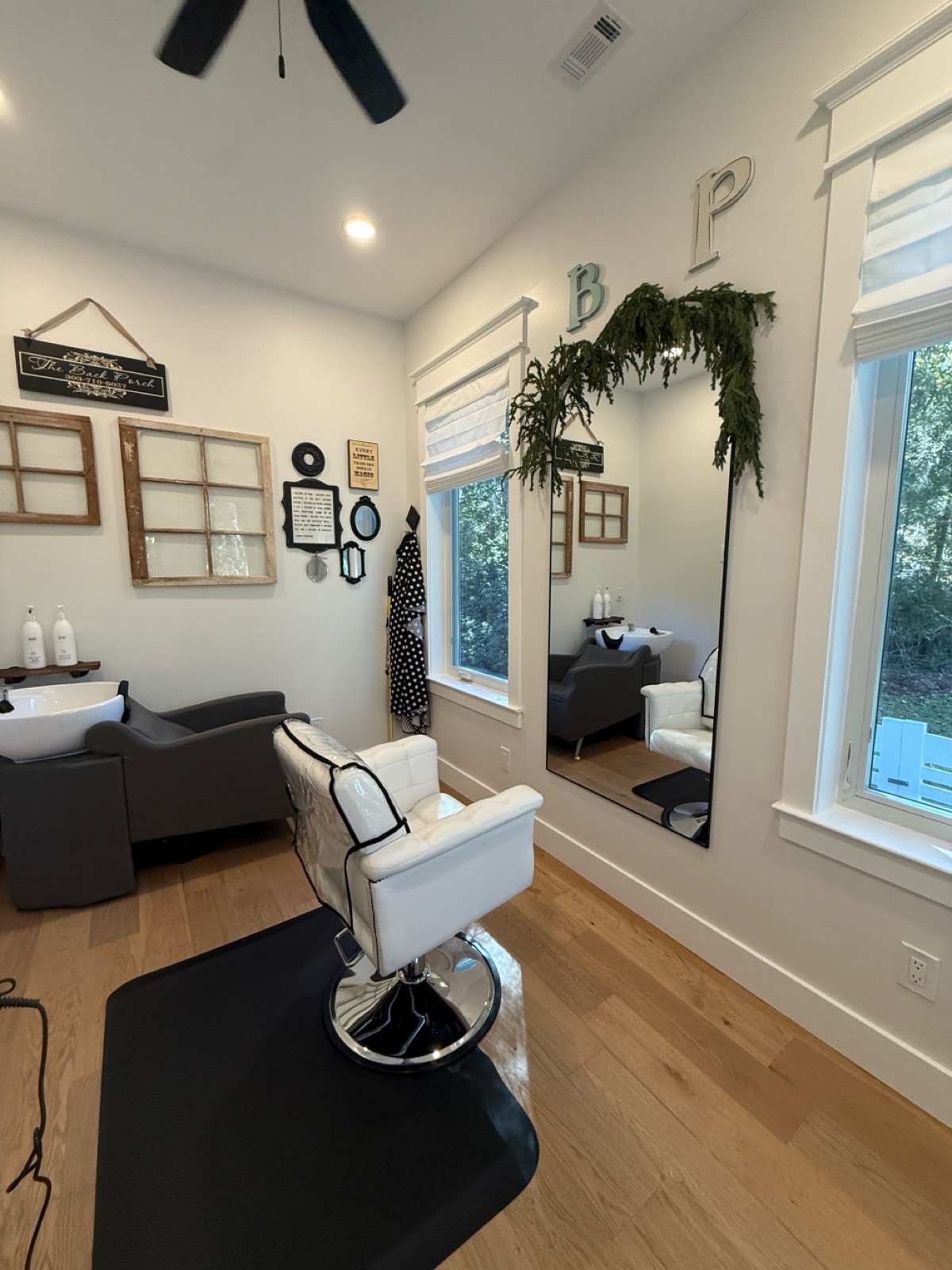 The one-chair studio with vintage window frames and The Back Porch sign